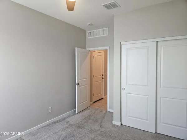 an empty room with windows and fan