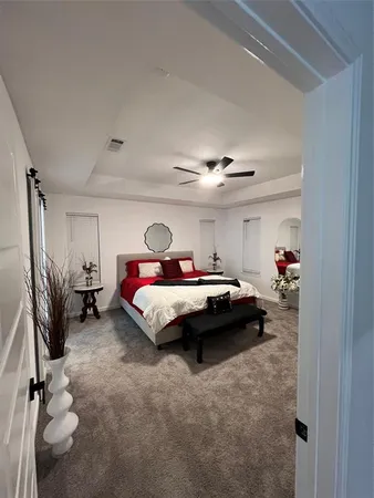 a spacious bedroom with a bed and a chandelier