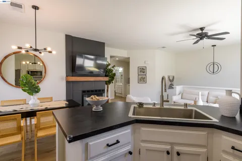 a kitchen with a sink dishwasher a fireplace with wooden floor