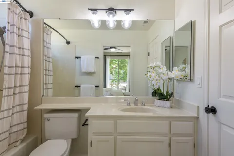 a bathroom with a granite countertop sink a toilet and shower