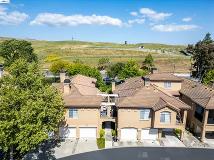 an aerial view of residential houses with outdoor space and ocean view