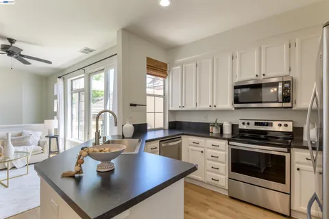 a kitchen with kitchen island a sink stove and microwave