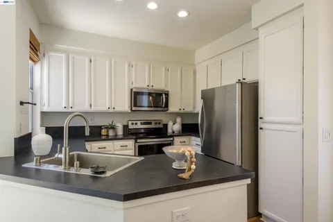 a kitchen with stainless steel appliances granite countertop a sink a stove and a refrigerator