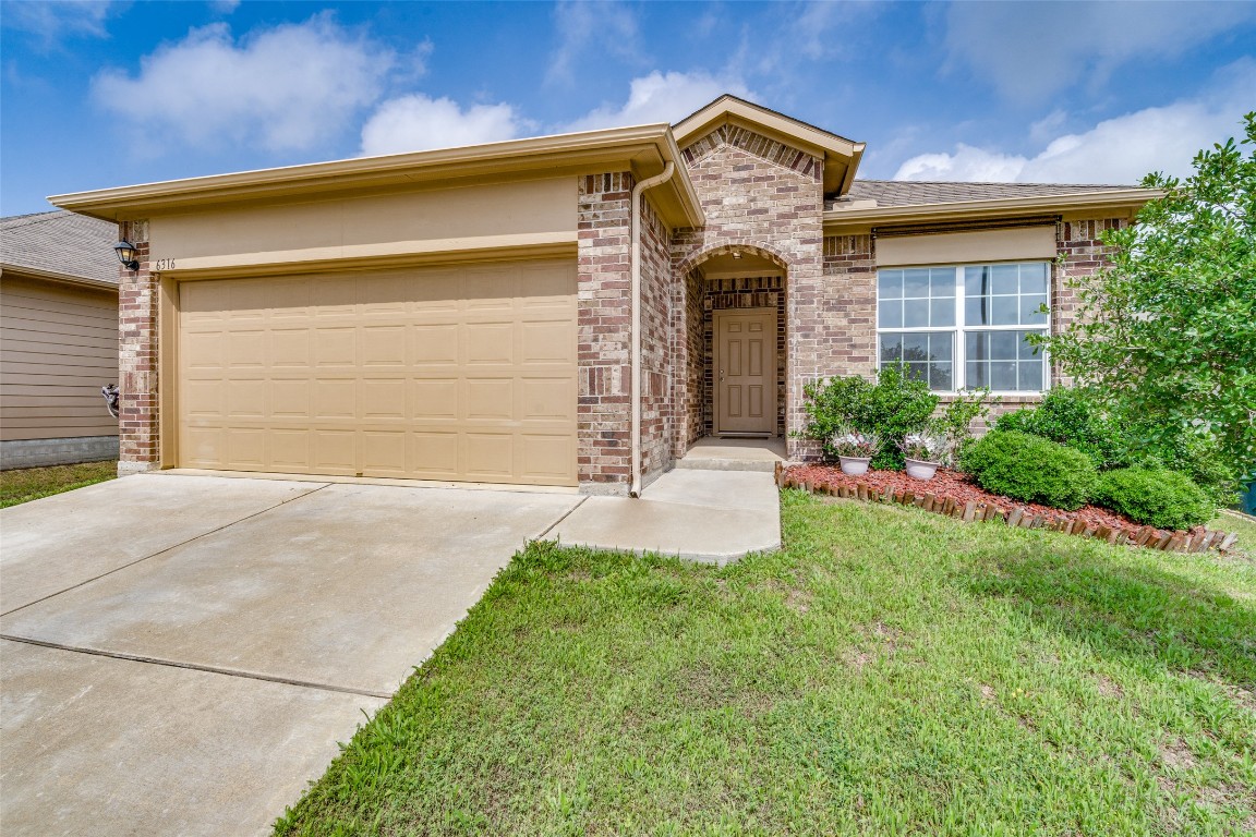 6316 Diamondleaf Bend Austin, TX 78724 - Photo 2 of 25 View of front of house with driveway, a front yard, brick siding, and a garage