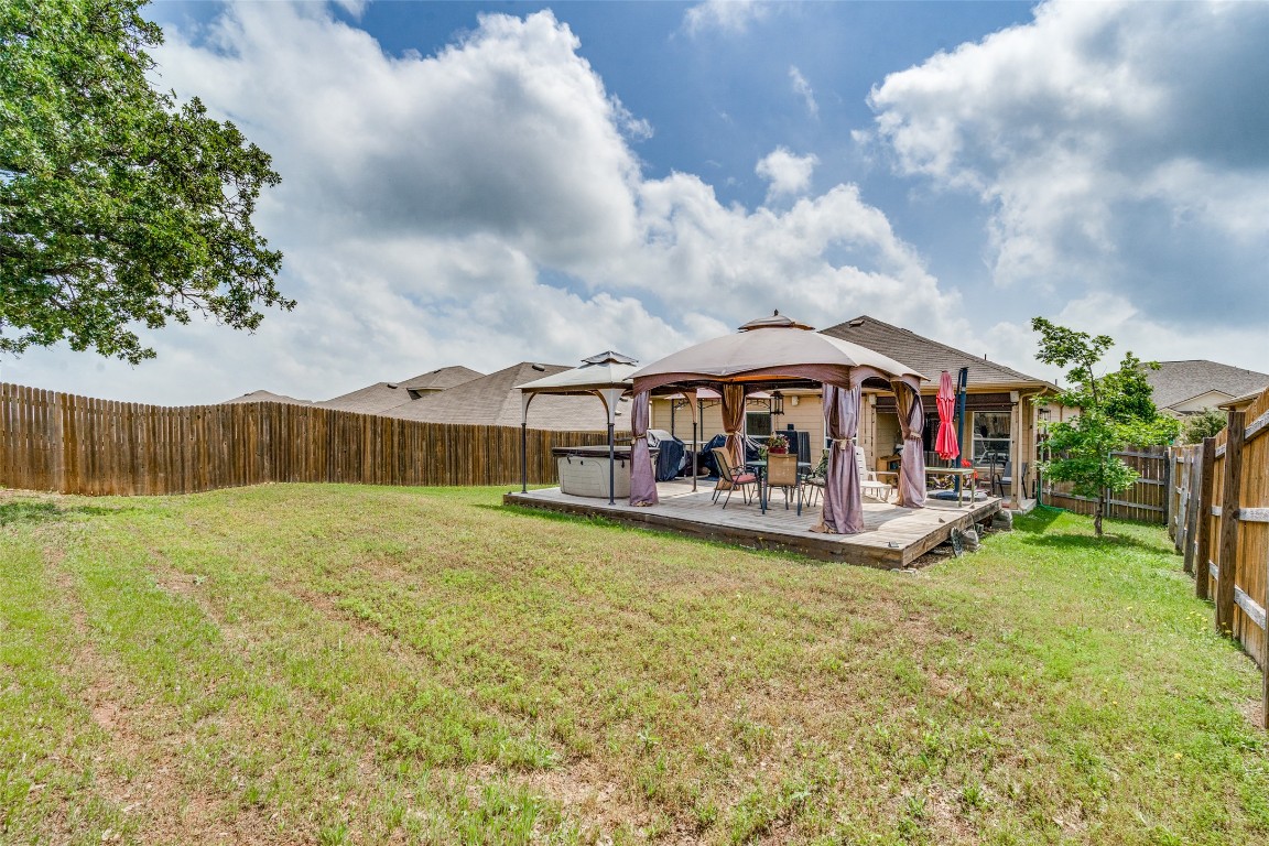 6316 Diamondleaf Bend Austin, TX 78724 - Photo 24 of 25 Back of property featuring a hot tub, a fenced backyard, and a deck