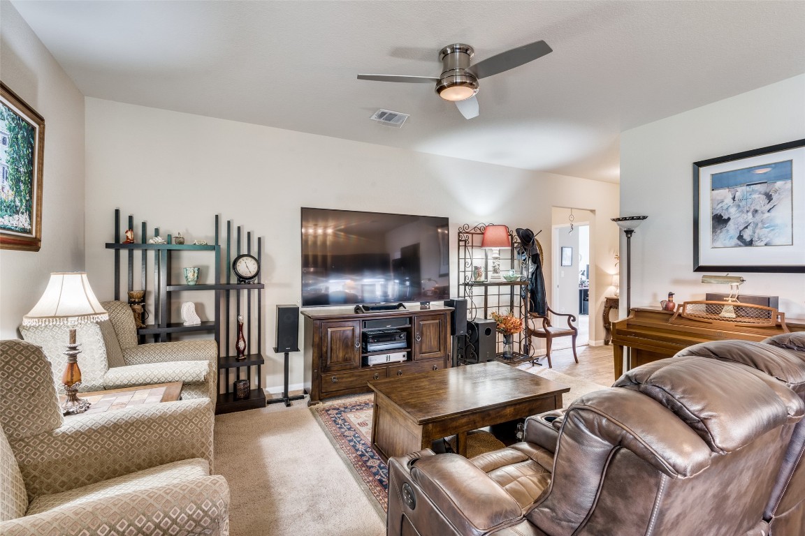 6316 Diamondleaf Bend Austin, TX 78724 - Photo 7 of 25 Carpeted living room with a ceiling fan and baseboards