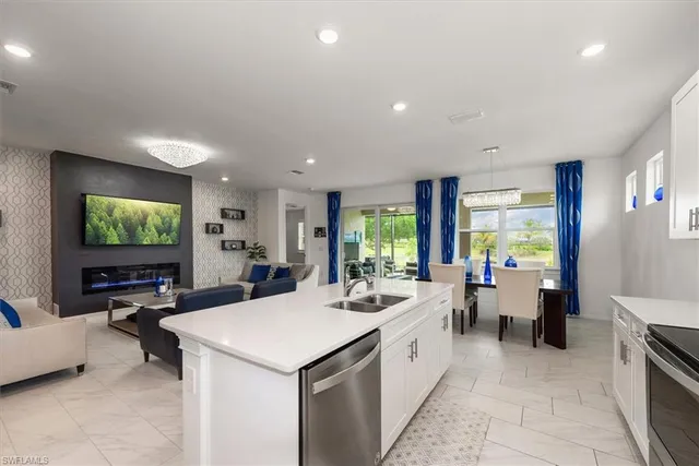 a large white kitchen with a large window and furniture
