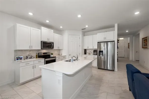 a kitchen with refrigerator a sink and cabinets