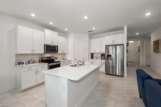 a kitchen with refrigerator a sink and cabinets
