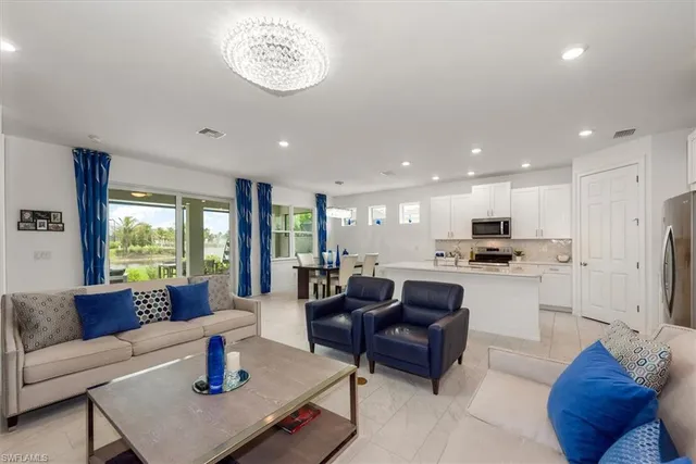 a living room with stainless steel appliances furniture and a large window