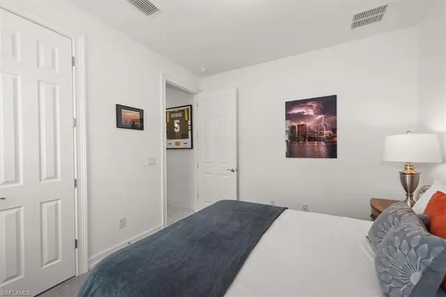 a bedroom with a bed and a painting on the wall