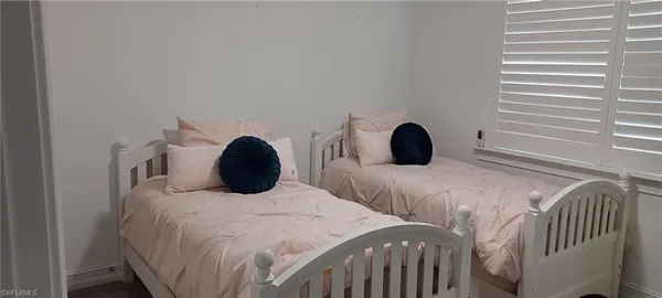 a bedroom with two beds and a window