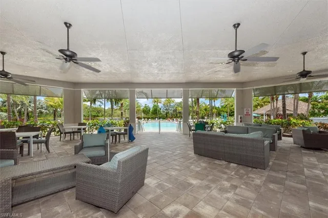 a living room with patio furniture and a potted plant