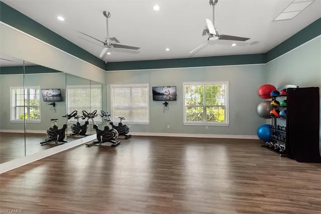 a view of a room with wooden floor chandeliers and a ceiling fan