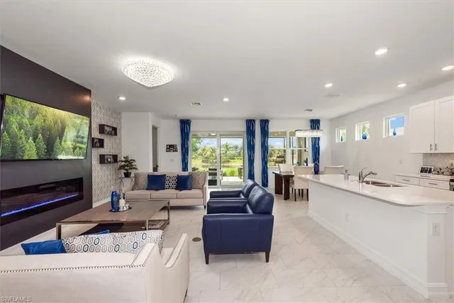 a living room with stainless steel appliances furniture and a flat screen tv