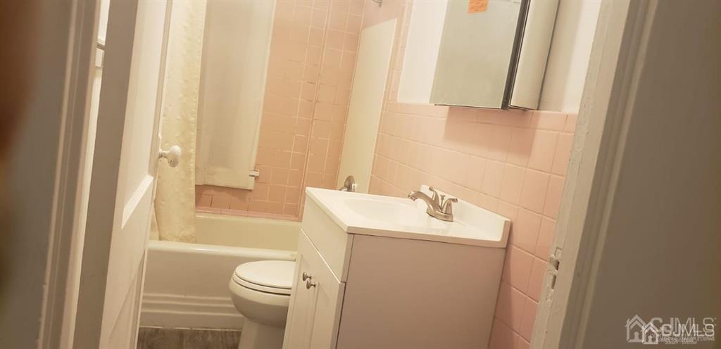 417 Chestnut Street, Unit B Middlesex, NJ 08846 - Photo 12 of 12 a bathroom with a sink a toilet and shower curtain