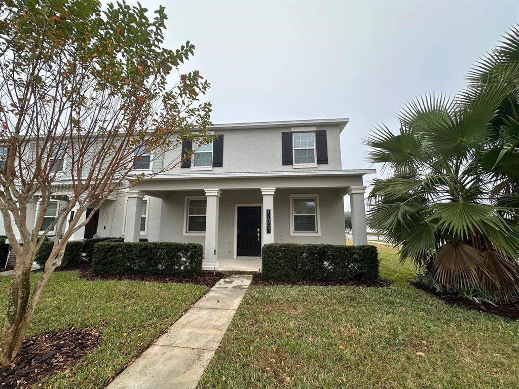 a front view of a house with a yard and potted plants