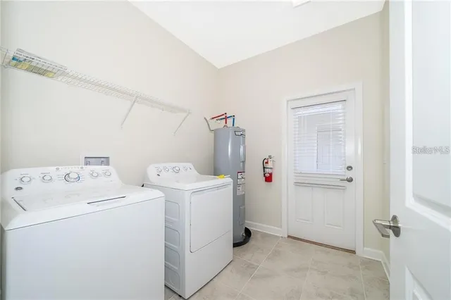 a view of washer and dryer with bathroom in the background