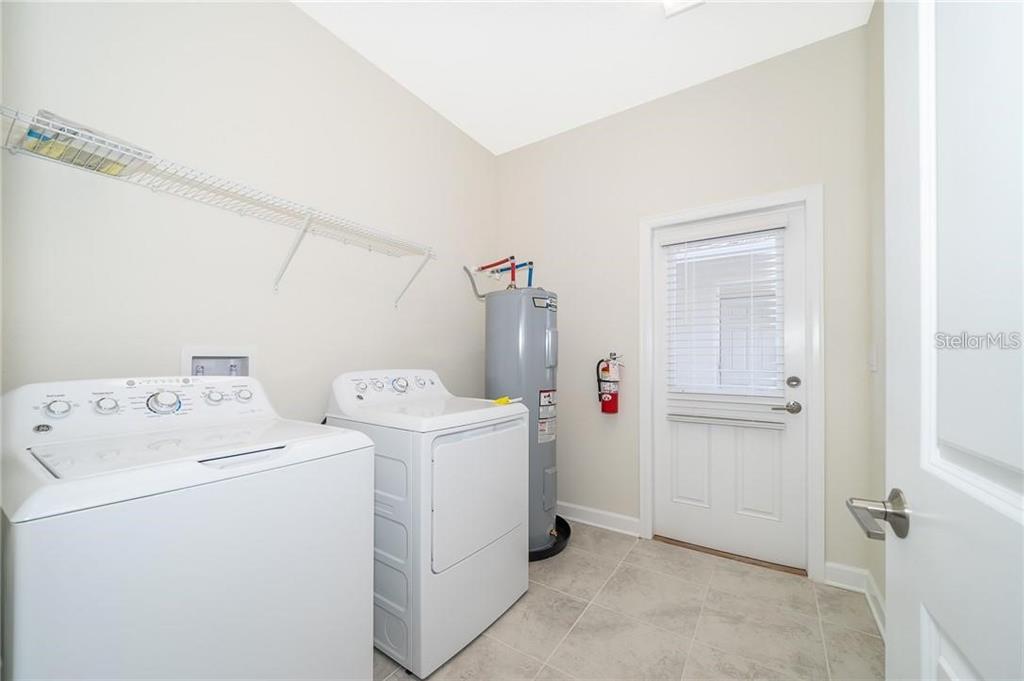 17053 Volume Alley Winter Garden, FL 34787 - Photo 13 of 15 a view of washer and dryer with bathroom in the background