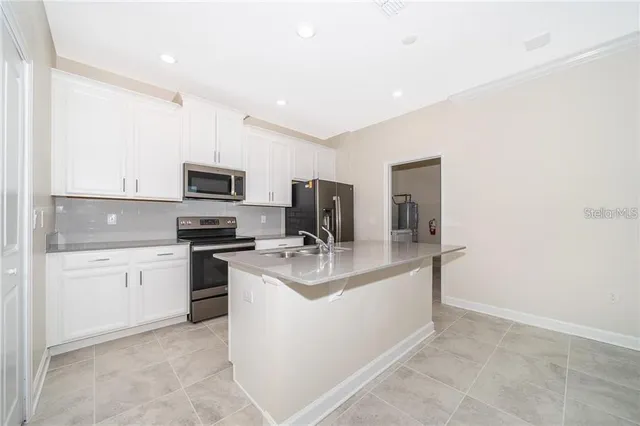 a kitchen with a sink stove and microwave