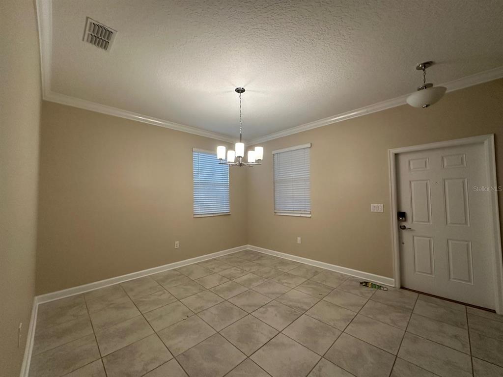 17053 Volume Alley Winter Garden, FL 34787 - Photo 3 of 15 an empty room with windows and chandelier