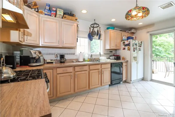 a kitchen with a white cabinets and window