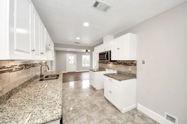 a kitchen with a stove top oven and white cabinets