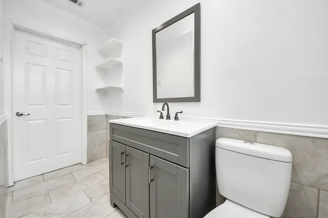 a bathroom with a toilet sink and mirror