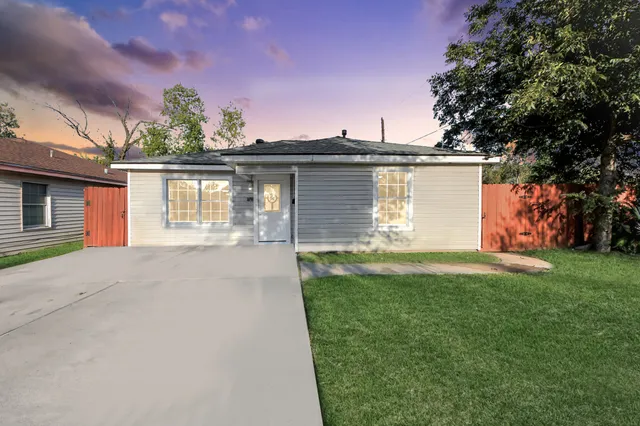 a front view of a house with a garden and yard