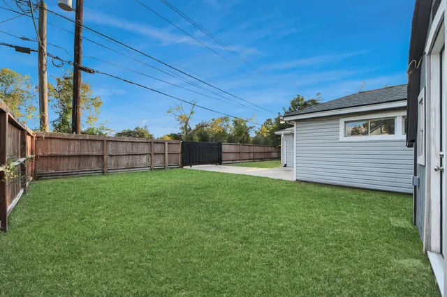 a view of a backyard with wooden fence and a bench