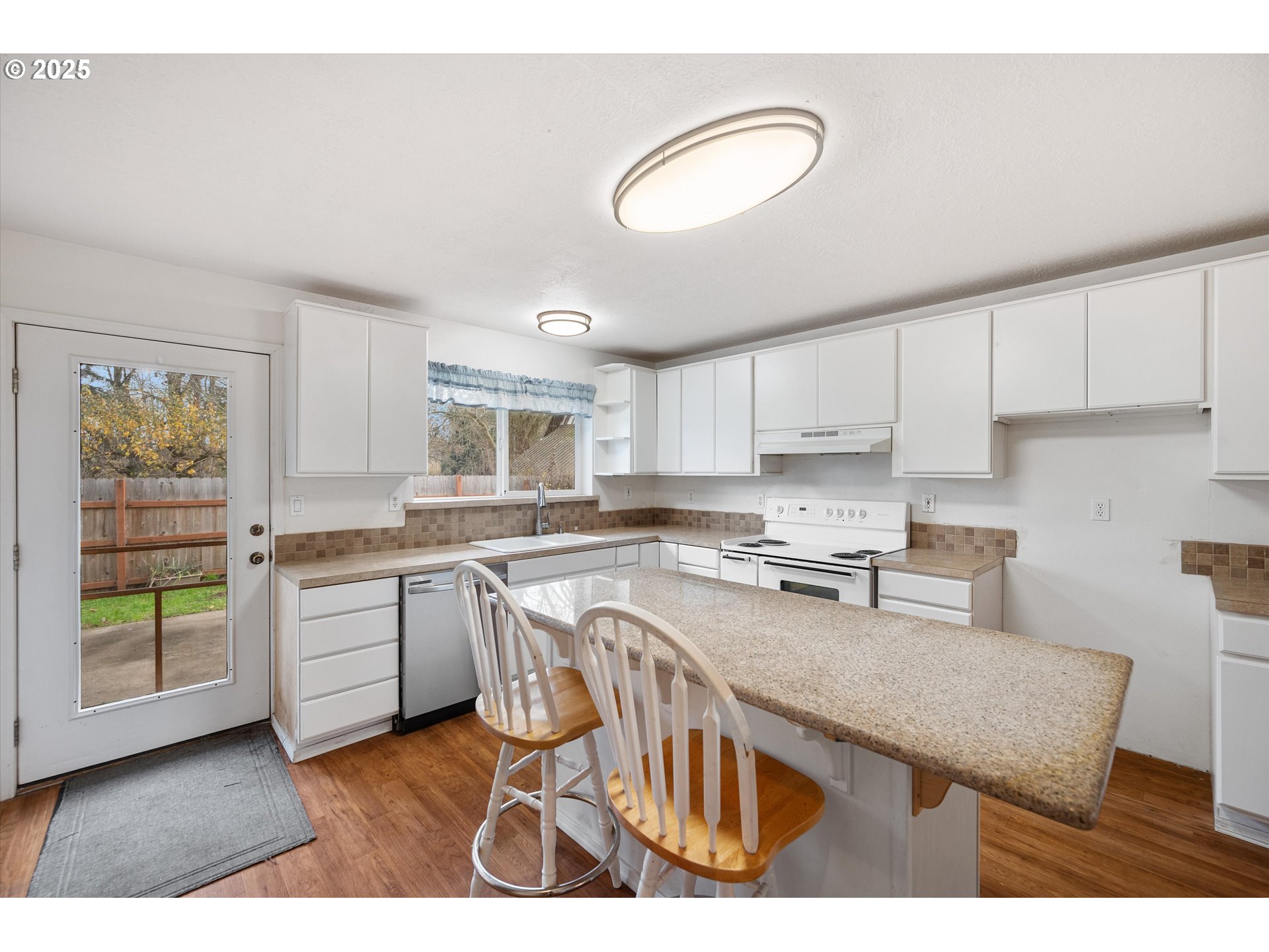 9620 Wells Landing Road Independence, OR 97351 - Photo 8 of 22 a kitchen with granite countertop a stove top oven a sink a dining table and chairs