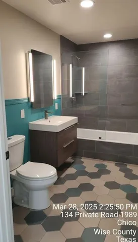 a bathroom with a sink a toilet and mirror