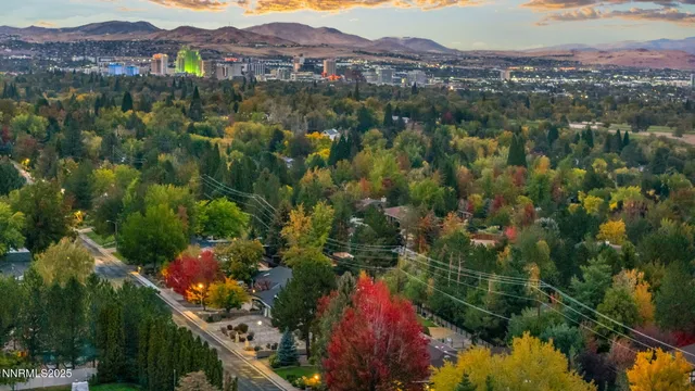 a kitchen with stainless steel appliances kitchen island granite countertop a stove a sink a oven a dining table and chairs with wooden floor