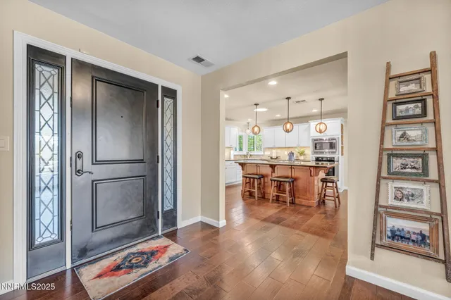 a view of a livingroom with wooden floor and furniture