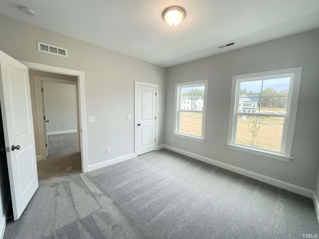an empty room with windows and closet