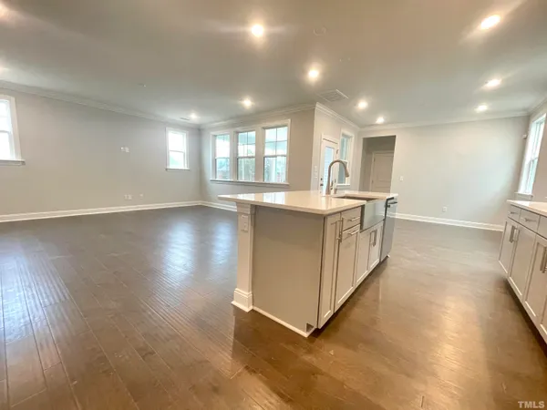 a large kitchen with stainless steel appliances granite countertop a lot of counter space and wooden floor