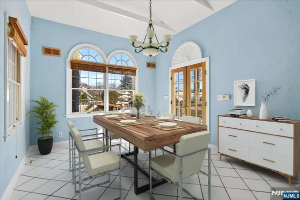 a dining room with furniture a chandelier and window