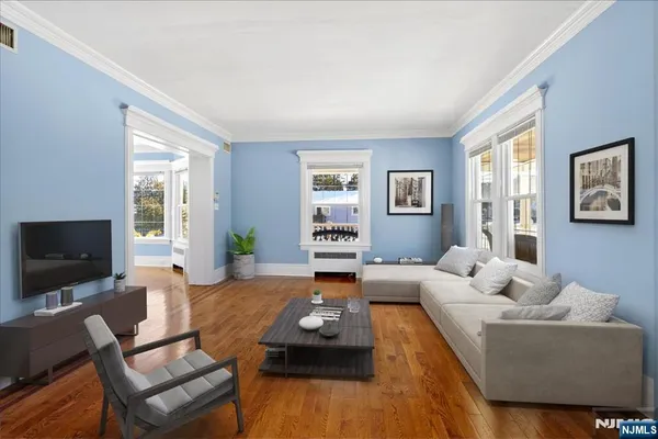 a living room with furniture flat screen tv and large window