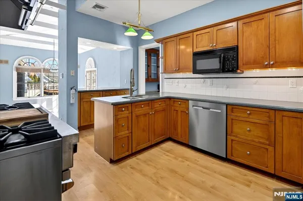 a kitchen with stainless steel appliances granite countertop a stove and a microwave
