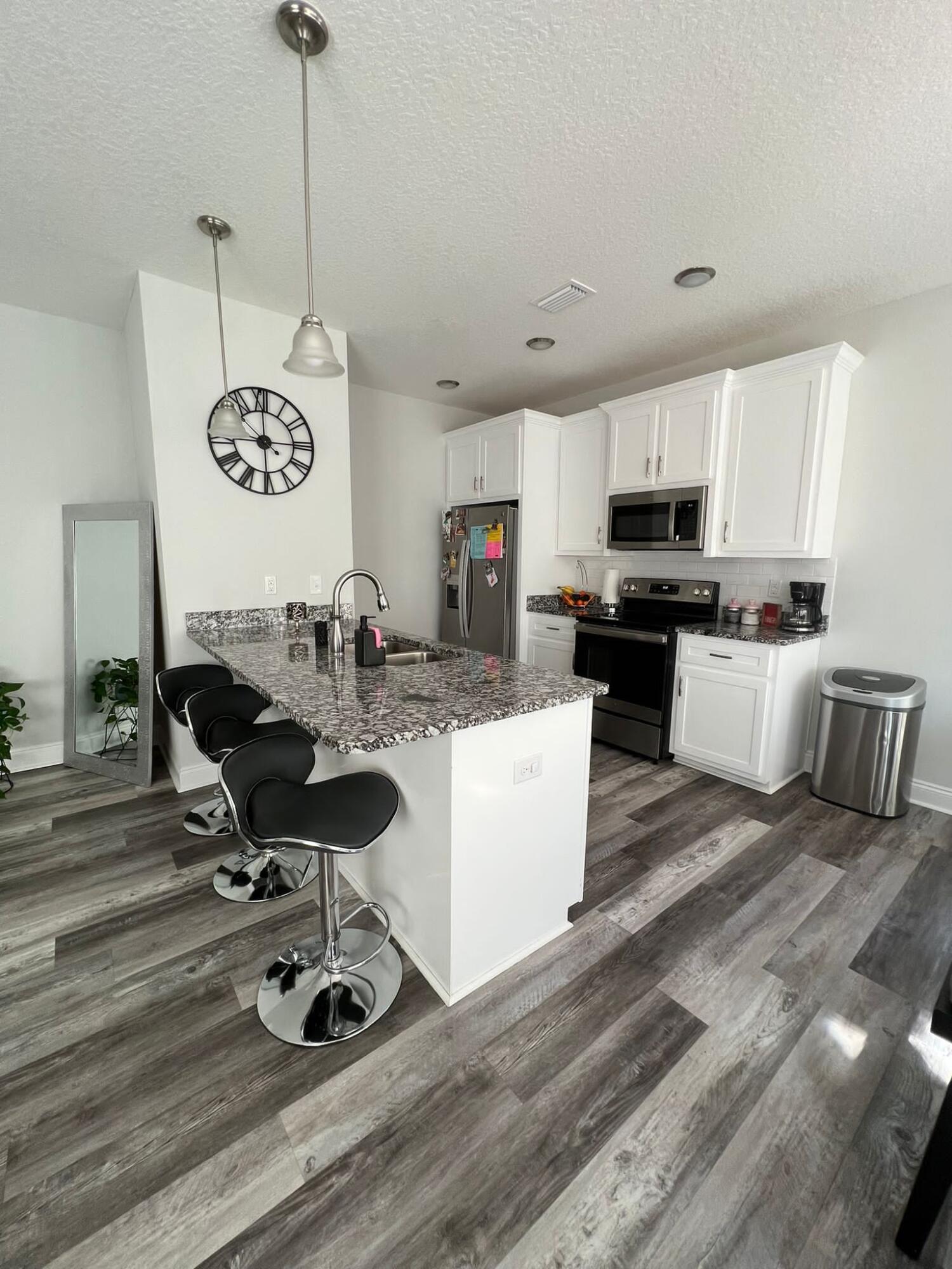 5791 Kellie Drive Crestview, FL 32539 - Photo 4 of 8 a living room with kitchen island stainless steel appliances furniture a kitchen view and a wooden floor