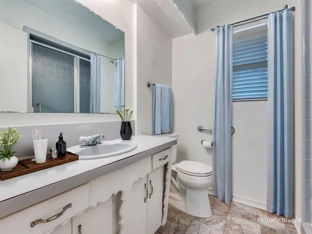 a bathroom with a sink a toilet a shower and a mirror