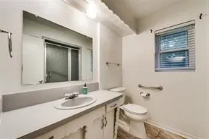 a bedroom with a bed a couch and a flat tv screen on dresser