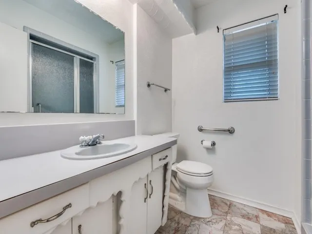 a bathroom with a sink a toilet and a mirror