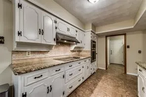 a kitchen with granite countertop a sink and cabinets