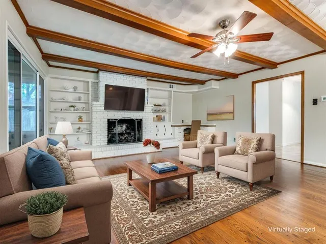 a living room with furniture a fireplace and a ceiling fan
