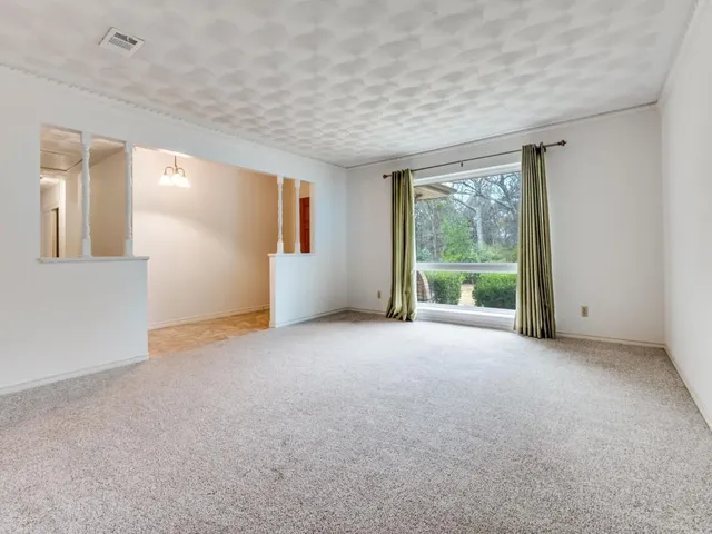 a view of a big room with windows and chandelier fan