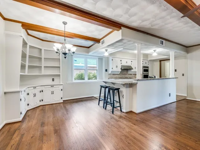 a view of a kitchen with cabinets and wooden floor