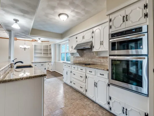 a kitchen with stainless steel appliances granite countertop a stove microwave and cabinets