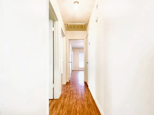 a view of a hallway with wooden floor