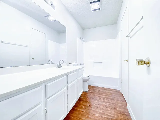 a spacious bathroom with a double vanity sink and mirror